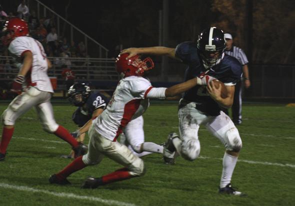 Warren Bauman, Saints' quarterback, stiff-arms North Branch Vikings on homecoming