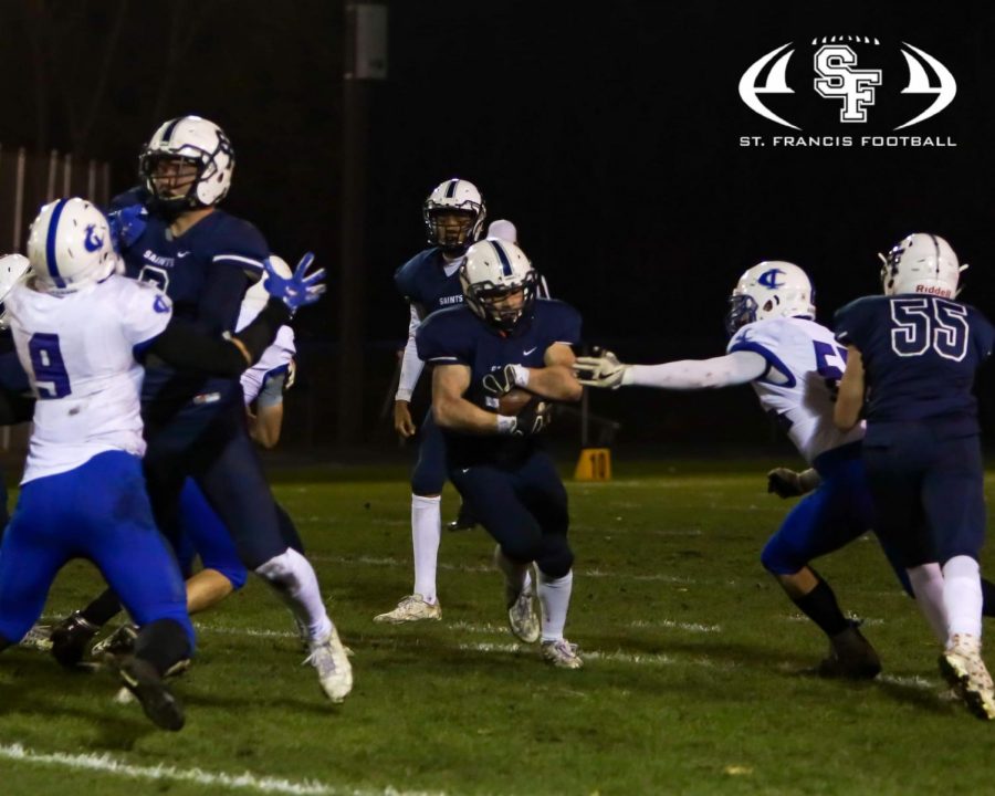 The Saints' Jordan Haller carries the ball low and tough in the first playoff game against Cambridge-Isanti. The Saints won 37-7.