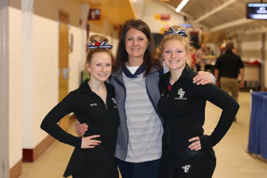 Girls gymnasts pose with their coach before heading off to state competition.