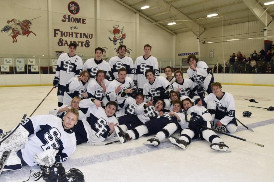 The+Saints+Boys+Hockey+team+poses+on+the+ice+for+a+team+picture.