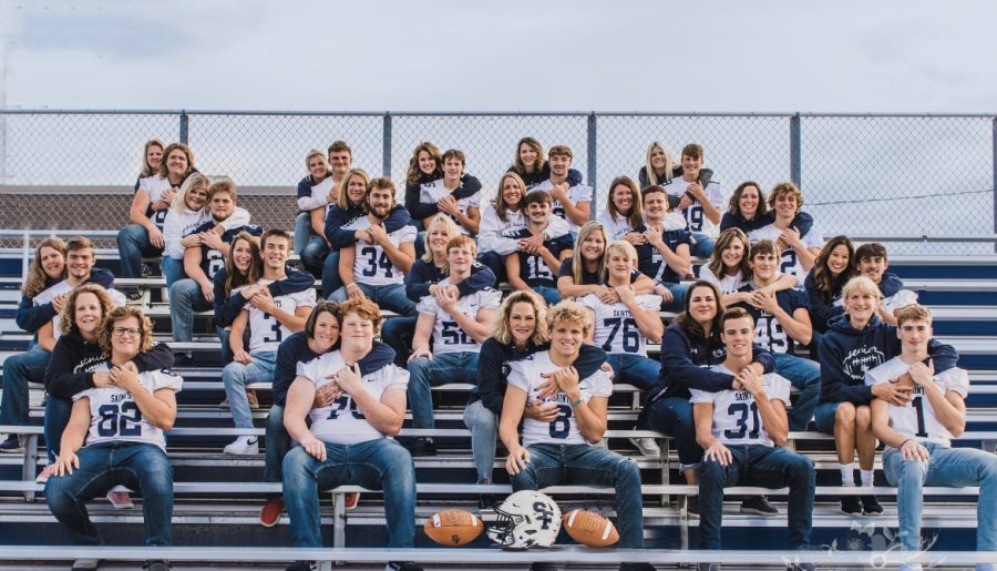 Senior Varsity Football players with their moms in the stands.