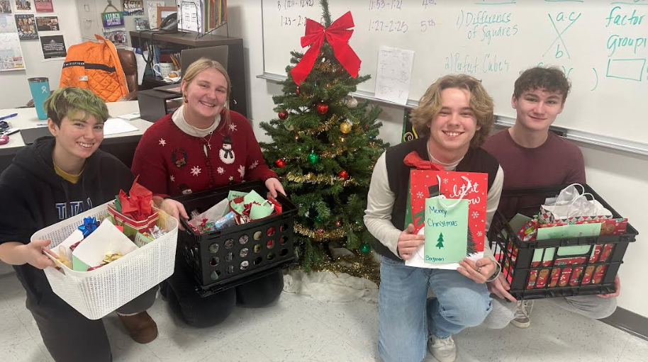 Four of the five National Honor Society officers posing next to a Christmas tree during the distribution of the Secret Santa Gifts.

Pictured from left to right: Hailey King-Steele (Vice President), Rachel Kopet (Activities Coordinator), Riley Brennhofer (President), Joseph Zandlo (Treasurer).

Not pictured: Kiersten Terris (Secretary), Sharon Bergman (Adviser).