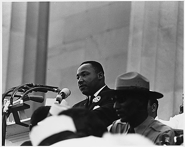 Public Domain photo of MLK speaking. Additional source and credit info from the National Archives.