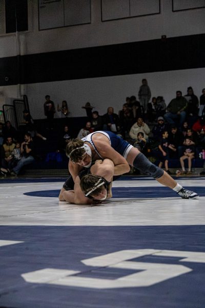 Junior Kenny Ferrario on-top of a Becker Bulldog wrestler